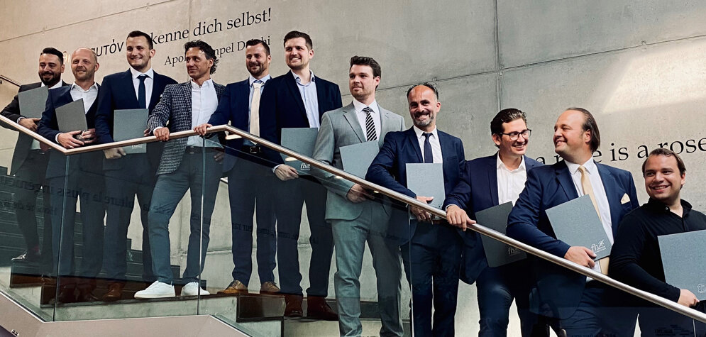 mba_sponsion_2023 | © FH Kufstein Tirol Männer auf der Treppe der Aula der FH Kufstein Tirol mit ihren Abschlussurkunden. | © FH Kufstein Tirol