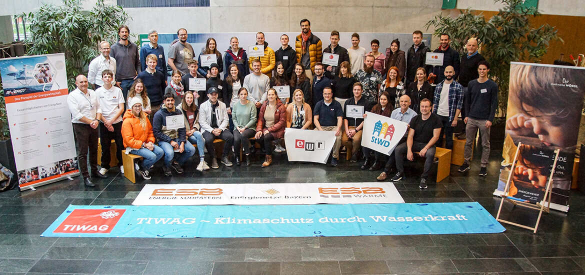 Energy-Next-Workshop-Teilnehmende | © FH Kufstein Tirol Teilnehmer:innen des Energy Next Workshops stehen und sitzen hinter einem Banner für Klimaschutz durch Wasserkraft und zeigen ihr Engagement für nachhaltige Geschäftspraktiken. | © FH Kufstein Tirol
