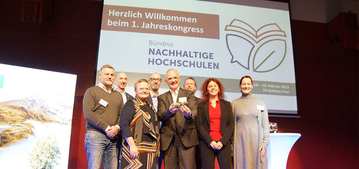 Vorstand-Buendnis-Nachhaltige-Hochschulen-Jahreskongress-FH-Kufstein-Tirol | © FH Kufstein Tirol Mitglieder des Vorstands des Bündnis Nachhaltige Hochschulen und Geschäftsführer der FH Burgenland beim ersten Jahreskongress, mit Veranstaltungsdetails auf dem Bildschirm. | © FH Kufstein Tirol