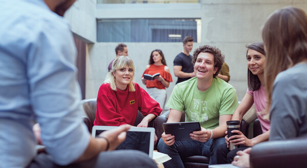 Aula_Gruppenprojekt_1 | © FH Kufstein Tirol Eine Gruppe sitzt in einem Stuhlkreis in der Aula, und bespricht etwas miteinander. | © FH Kufstein Tirol