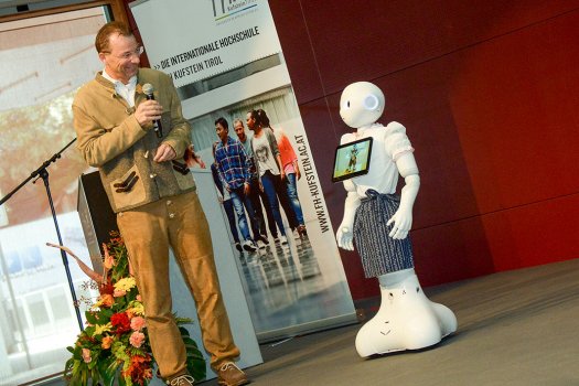 FH-Geschäftsführer Prof. (FH) Dr. Thomas Madritsch im Gespräch mit Roboter Pepper