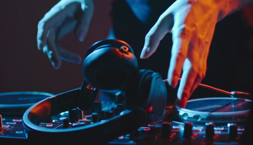 DJ Pult in Nahaufnahme auf dem Kopfhörer liegen nach denen gerade gegriffen wird